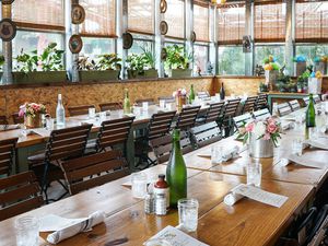 Long dining table with place settings, flowers and green bottles of water