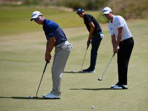 John Senden (L) of Australia putts alongside two other golfers during a practice round prior to the start of the 2015 U.S. Open