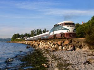 amtrak cascades train running along rocky waterfront