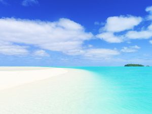 white sand beach with turquoise sea and blue sky with white clouds