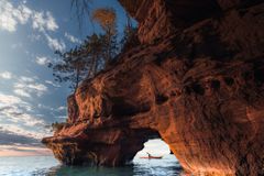 A lone kayaker exits a sea cave on The Apostle Island National Lakeshore in Wisconsin in Fall.