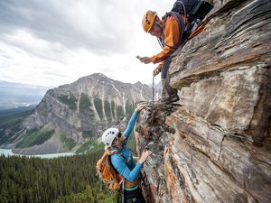 Climber takes picture of teammate ascending cliff