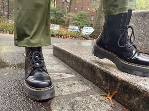 Person wearing the Dr. Martens Jadon 8-Eye Leather Platform Boot on concrete steps