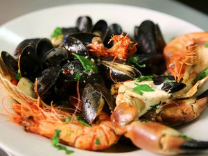 plate of mussels, head-on shrimp, crab, and scallops