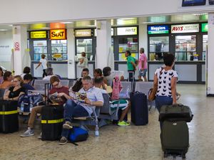 Airline passengers wait for a rental cars at Alghero Airport