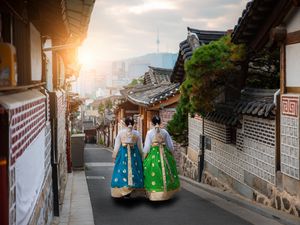 Two women dressed in hanbok dresses in Bukchon Hanok Village, Seoul, South Korea