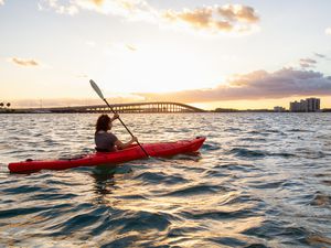 girl kayaking in front of a modern Downtown Cityscape during a dramatic sunset. Taken in Miami, Florida,