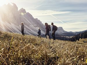 a family goes for a hike with mountains in the background.