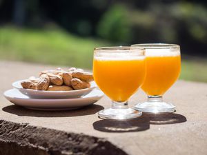 Poncha, a traditional alcoholic drink from the island of Madeira, Portugal, made with aguardente de cana and fresh passion fruit. Served along with peanuts.