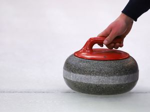 Cropped Hand Of Person Holding Curling Stone On Ice