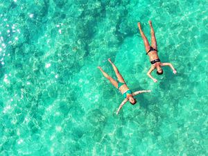 Women floating in crystal clear water