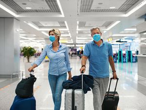 travelers wearing masks in airport