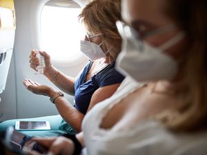 Woman Using Hand Sanitizer During Airplane Trip