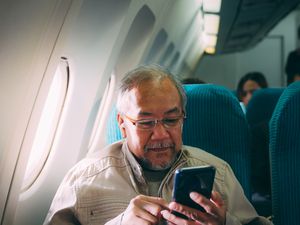 Man on plane with phone