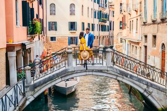 A couple standing on a bridge in Venice