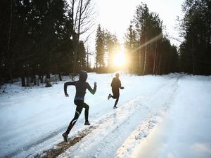 People running outdoors in the snow in winter running gear