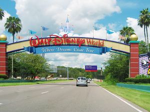 an entrance of Walt Disney World Resort. Some cars are visible.