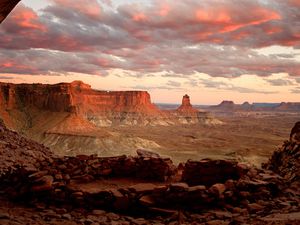 The red sandstone cliffs and towers of Canyonlands National Park stretch into distance.