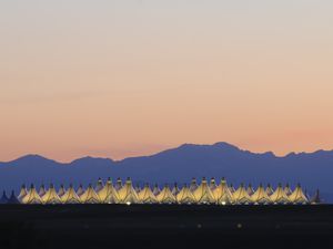 Denver International Airport at dusk with a mountain background