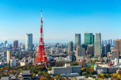 View of the red and white tokyo tower in the business district, photographed from a distance on a cloudless day