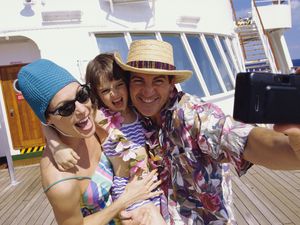 Close-up of a mid adult couple with their daughter taking a photograph of themselves