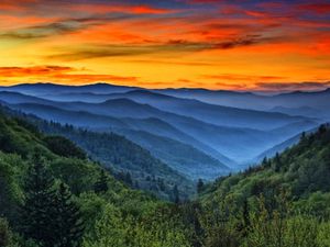 Sunset over a series of misty ridges and mountaintops