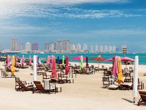 The public beach at Katara Cultural center in Doha, Qatar with closed, colorful beach umbrellas