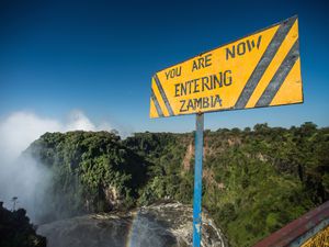 Sign marking the land border between Zambia and Zimbabwe at Victoria Falls