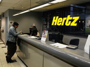 A customer talks with a Hertz car rental agent.
