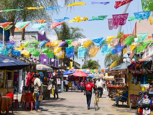 People shopping in Tijuana below colorful flags
