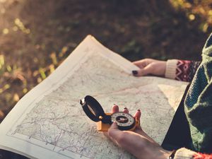 A hiker uses a map and compass to navigate