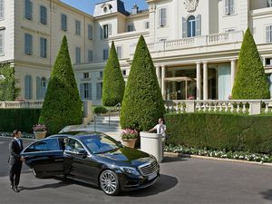 A person exiting a chaffeur driven car in front of Hotel du Cap-Eden-Roc