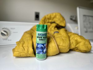 Nikwax Down Wash Direct displayed with yellow down jacket on a washing machine 