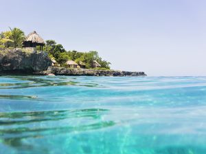 Jamaica, Negril, Traditional huts on rocky coastline