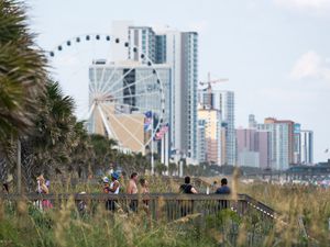 People walk to and from the beach in Myrtle Beach, South Carolina. 