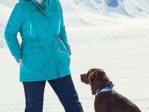 Plus-size woman in snow with dog