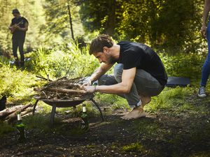 Man preparing a campfire in a brazier