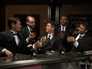 Men in dinner jackets drinking cocktails in bar