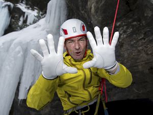 A climber showing his white gloves used for dry tooling climb.