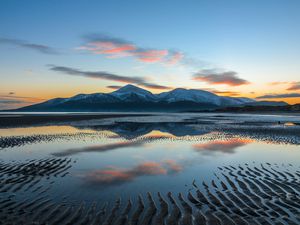 mourne mountains at sunset reflected in the ocean