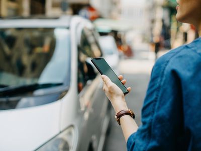 Woman ordering a rideshare with mobile app on smartphone in the city