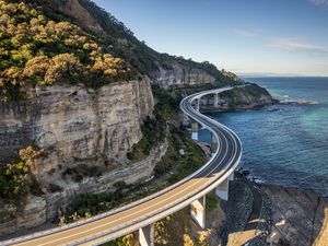 Sea Cliff Bridge, rocky coast road, highway and mountain, aerial view