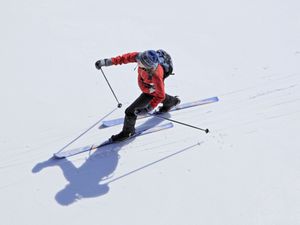 Aerial view of a female nordic cross country skier skiing across a frozen lake