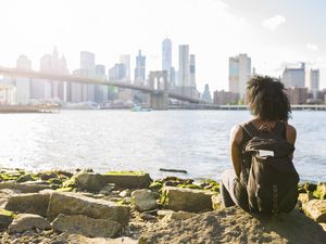 USA, New York City, Brooklyn, woman sitting at the waterfront